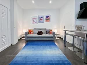 - un salon avec un canapé et un tapis bleu dans l'établissement Tivoli 1 - Renovated studio, Monaco Border, 5mn from Casino Monte Carlo, à Beausoleil