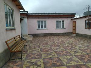 a bench sitting on a patio next to a building at Guesthouse Arnas in Bokonbayevo