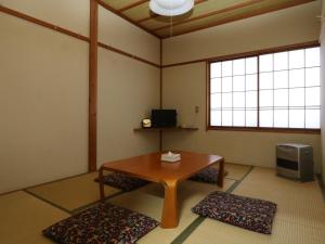 a living room with a table and a tv at みつまたロッヂ in Yuzawa
