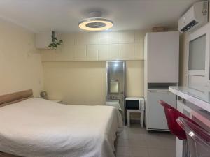 a small bedroom with a white bed and a kitchen at Small apartments in Lamone in Lamone