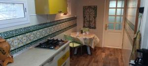 a kitchen with a stove and a table and a window at La Brise Marine in Sousse