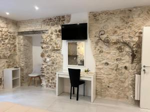 a room with a desk and a stone wall at Il viandante in Sulmona