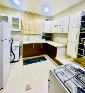 a kitchen with white cabinets and a white refrigerator at Haven in Makkah