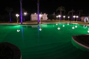 a swimming pool lit up at night with lights at Villaggio Jonio Blu in Bianco