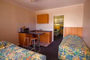 a hotel room with two beds and a kitchen at Bamboo Motor Inn in Lakes Entrance