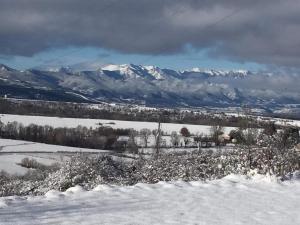 a snow covered field with mountains in the background at LES FONTANILLES odeillo chalet 60 WIFI & PARKING gratuit exposé plein sud & plein pied , draps & serviettes de toilettes non inclus, sabanas y toallas no incluidos in Font-Romeu-Odeillo-Via