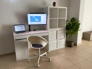 - un bureau informatique blanc avec un moniteur et un ordinateur portable dans l'établissement KIMRAY Boutique Apartment - Indulge in Comfort, Embrace Tranquility, à Marsaskala