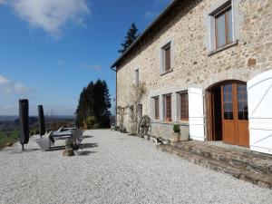 a stone building with benches in front of it at Chambre d'hôtes Le Puy Maury in Augne