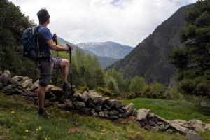 a man with a backpack standing on top of a mountain at Hotel Comtes d'Urgell by Nexta in Andorra la Vella