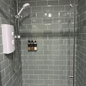uma casa de banho com chuveiro e duas garrafas na parede em Tigh an Eilean Hotel em Shieldaig