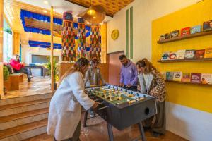 a group of people playing a game on a table at The Hosteller Mcleodganj, Bhagsu in McLeod Ganj