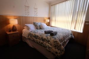 a bedroom with a bed with two towels on it at Bamboo Motor Inn in Lakes Entrance