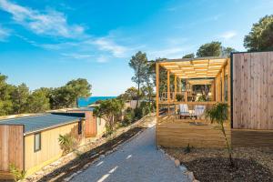 a home with a wooden facade with a patio at Obonjan Island Resort in Šibenik