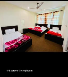 two beds in a room with red sheets at Hunza Hilton Hotel Gilget Baltestan in Gilgit