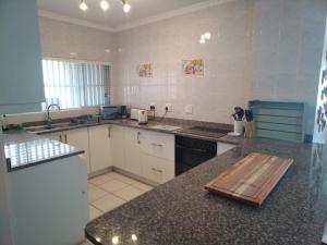 uma grande cozinha com um balcão e um balcão Sidx Sidx em Libra Holiday Flats 1 em Margate