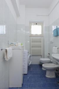 a white bathroom with a toilet and a sink at La Coccinella Sorrento in Sorrento