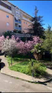 a building with pink flowering trees next to a street at Casa Di Luce in Montesilvano