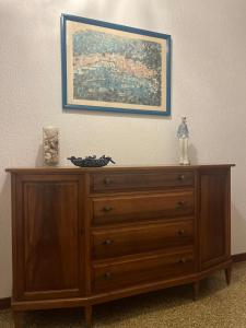 a wooden dresser in a room with a painting on the wall at La casa del marinaio in Genova