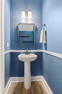 uma casa de banho azul com um lavatório e um espelho em Penny Lane Park Circle 15m dwtn CHS em Charleston