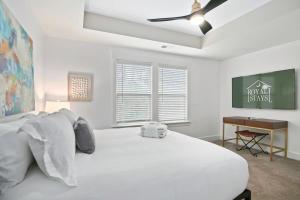 um quarto branco com uma cama e uma ventoinha de tecto em Penny Lane Park Circle 15m dwtn CHS em Charleston