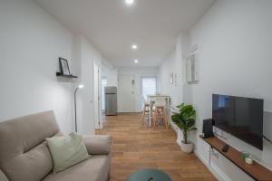 a living room with a couch and a flat screen tv at Stylish triplex-2Bedrooms 2Bathrooms-Ventas in Madrid