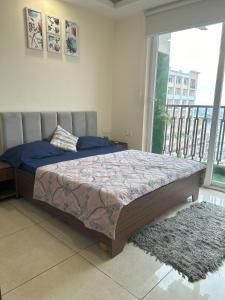 a bedroom with a bed and a large window at Stylish Stay by Good Vibes Studio in Zirakpur +25 photos