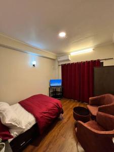 a bedroom with a bed and a red curtain at GSquare Serviced Appartment in Burhānilkantha