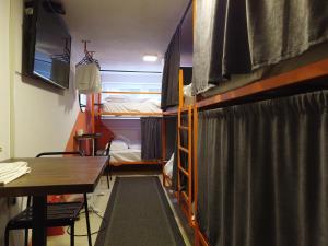 Cette chambre comprend 2 lits superposés et une table. dans l'établissement Nomad Hostel, à Pristina