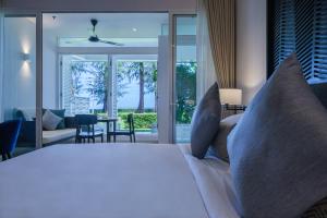 a bedroom with a bed and a view of the ocean at Lone Pine, Penang, a Tribute Portfolio Resort in Batu Ferringhi