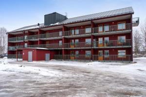 a red building with a parking lot in front of it at Elite Studio - Work & Rest in Piteå