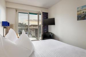 una camera d'albergo con letto e finestra di Merian Basel - Self Check-in a Basilea