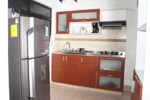 a kitchen with wooden cabinets and a stainless steel refrigerator at Medellin My Home in Medellín