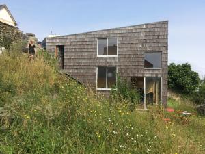 a person standing on the side of a house at Beautiful wood house and view in Audierne