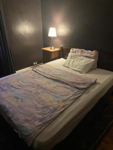 Abbey WoodにあるLarge double room next to Elisabeth Lineのベッドルームに毛布付きのベッド1台