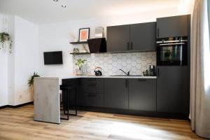 a kitchen with black cabinets and a counter at Urban Jungle Apartments in Vienna