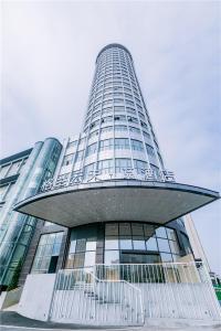 a tall glass building with a large building at The Skytel Hotel Shenzhen International Convention and Exhibition Center in Shenzhen