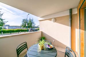 a table and chairs on a balcony at New Splendid Appt Terrace - 5 min Disneyland Paris in Montévrain