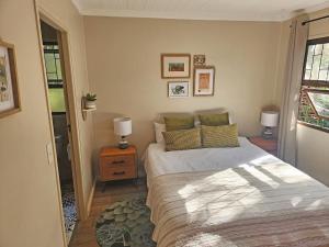 ネイチャーズ・バリーにあるNature's Edge Cabinのベッドルーム1室(ベッド1台、ランプ2つ付きのテーブル付)