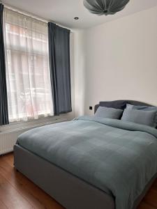 ein Schlafzimmer mit großem Bett und Fenster in der Unterkunft Cozy Corner in Rotterdam in Rotterdam