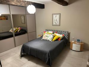 sypialnia z łóżkiem i dużym lustrem w obiekcie Entre couleurs et senteurs w mieście Mirabel-aux-Baronnies