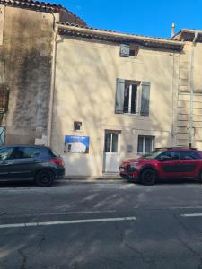 two cars parked in front of a building at Le love baroque in Lézignan-la-Cèbe