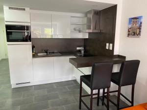 a kitchen with white cabinets and black chairs at Ferienwohnung Leonie in Rottweil in Rottweil