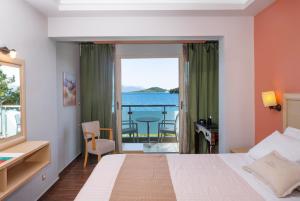 a hotel room with a bed and a view of the ocean at Armeno beach hotel in Nydri