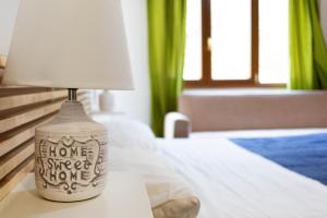 una lámpara sentada en una mesa junto a una cama en La Vittoria, en Lido di Ostia