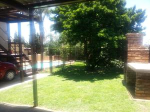 a yard with a tree and a fence at Private Apartments & Biz Stays Pretoria in Pretoria