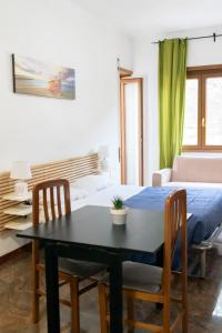 Una sala de estar con una mesa y sillas y un sofá. en La Vittoria, en Lido di Ostia