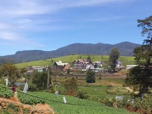 a village on a hill with mountains in the background at American Star Hotel- Nuwaraeliya in Nuwara Eliya