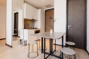cocina y comedor con mesa y taburetes en Louis Kienne Serviced Residences - Havelock en Singapur