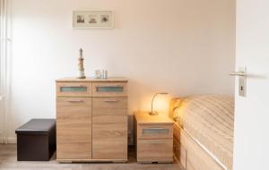 1 dormitorio con cama y tocador de madera en Ferienwohnung Theodor, en Schilksee