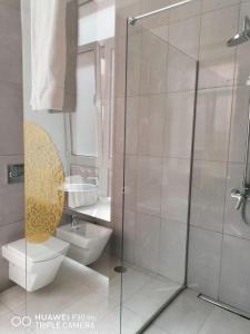 a bathroom with a toilet and a glass shower at Hortas Residence 13 in Funchal